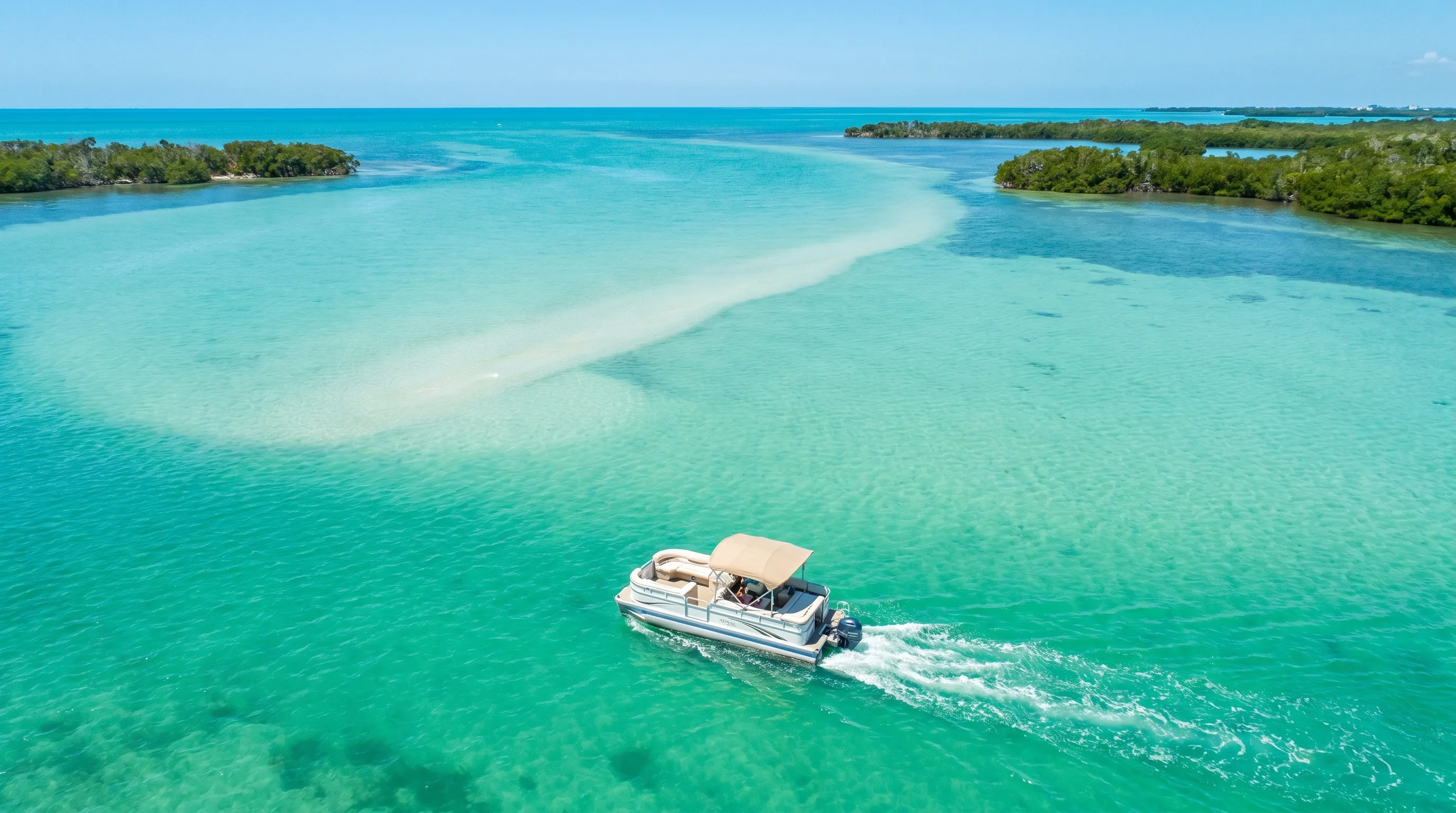 Aerial view of a pontoon boat cruising the turquoise waters of Estero Bay
